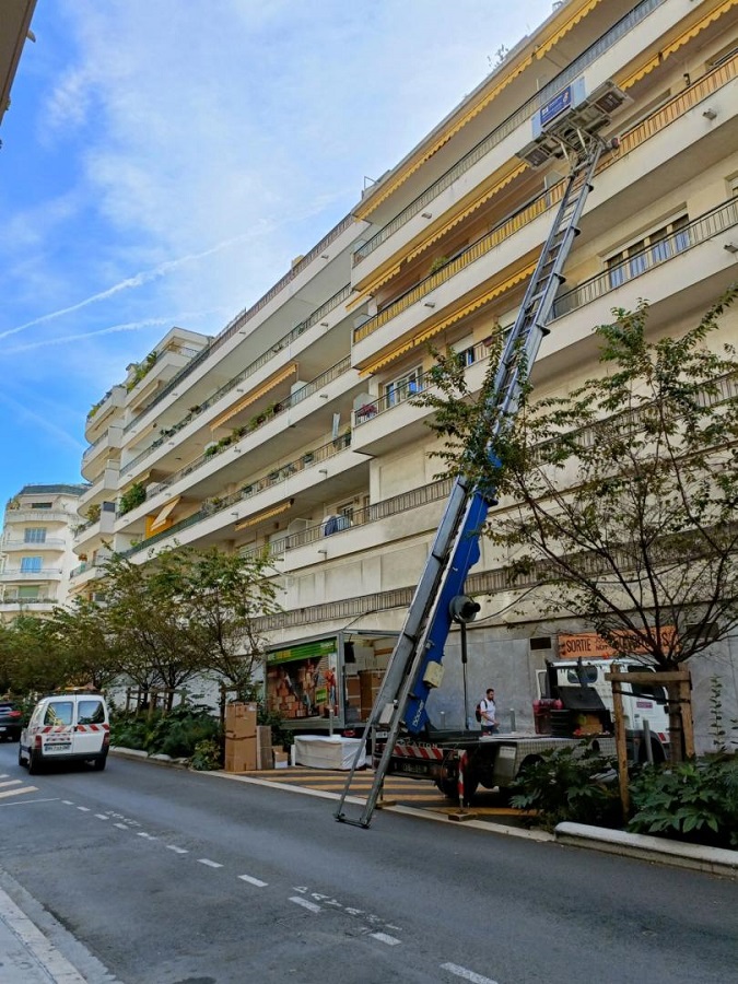 grue de déménagement déployée au bord d'une route