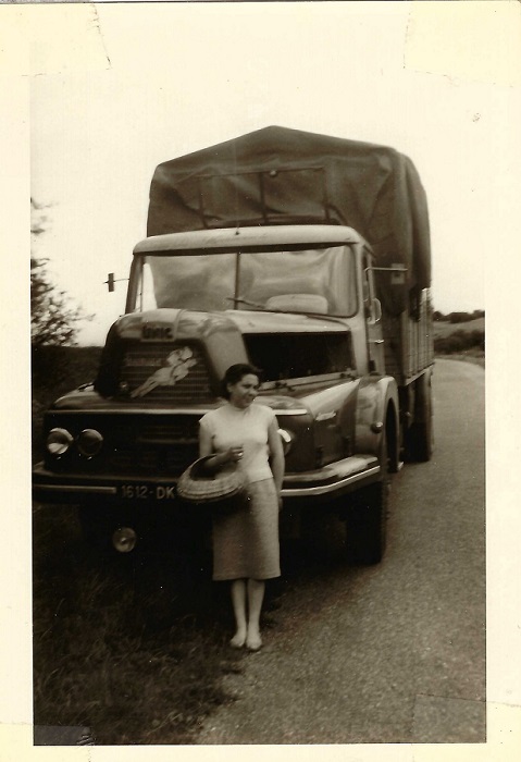 Femme debout prenant la pose devant un camion de déménagement