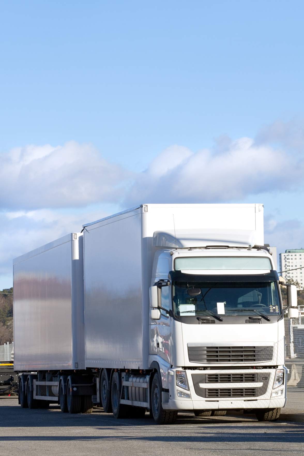 Une voiture dans un container transportée par camion